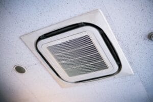 White ceiling-mounted cassette air conditioner unit installed in commercial interior