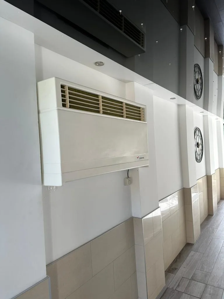Wall-mounted dehumidifier units installed in commercial indoor pool changing area